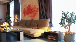 A living room with a sofa, coffee table, and a potted plant. - Korte Hotel Sleeps 14 With Courtyard (Mestia)