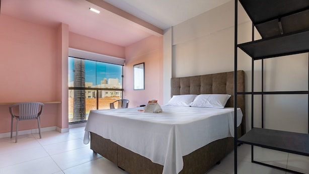 Una habitación de hotel moderna con una cama grande, un escritorio y una silla.