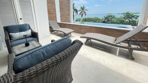 A balcony with wicker furniture, a view of the ocean, and a pool. - Welcome N/H Villa Paradise in enchanting Reading, Montego Bay with AC, Gym, WiFi (Reading)