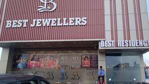Un edificio con insegne che riportano 'Best Jewellers' e 'Best Residency'.