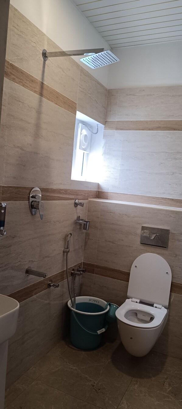 Un bagno con servizi igienici, doccia e finestra.