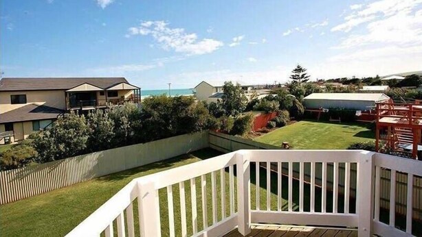 A residential area with a deck, a lawn, and houses in the background. - Alton Seas 67 Hargreaves Rd, Middleton (Middleton)