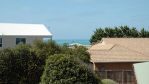Un quartier résidentiel avec des maisons, un ciel dégagé et une vue sur la mer.