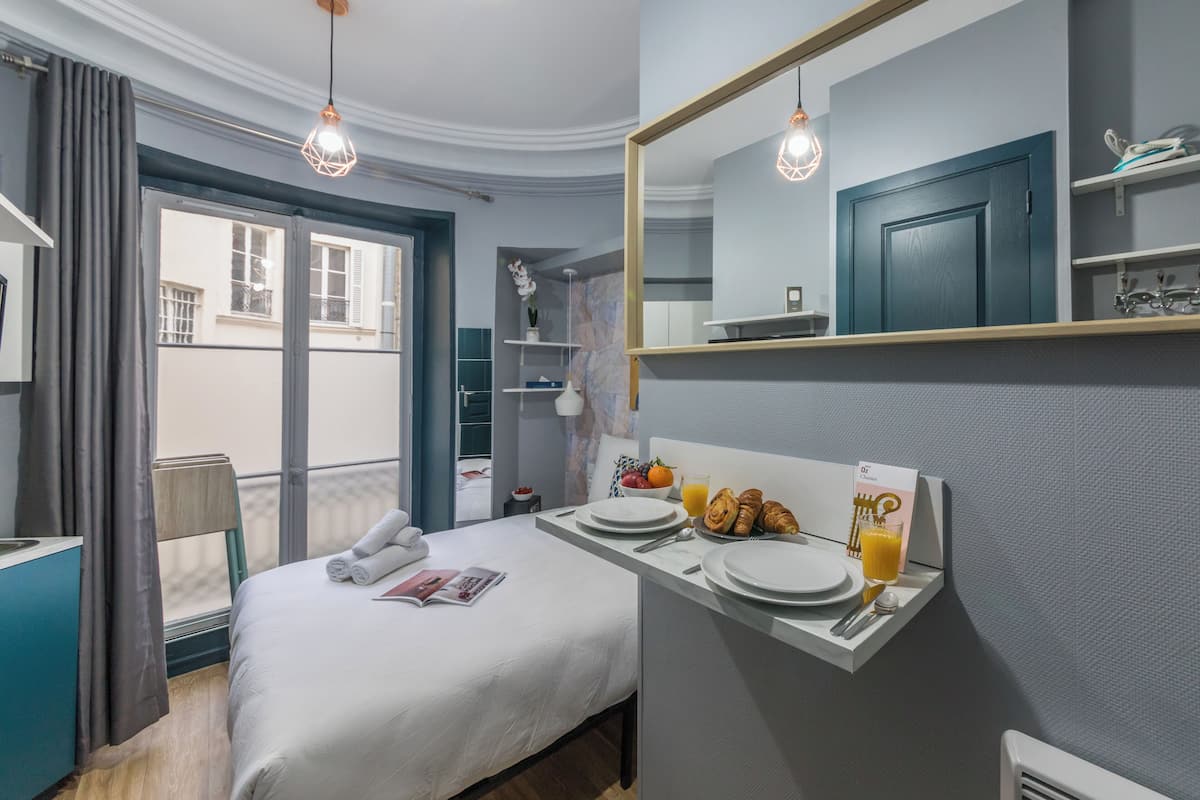 Une chambre d'hôtel avec un lit, un plateau de petit-déjeuner et une vue sur l'extérieur.