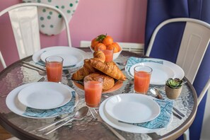 Ein Esstisch mit Croissants, Orangensaft und einer Orangenschale.