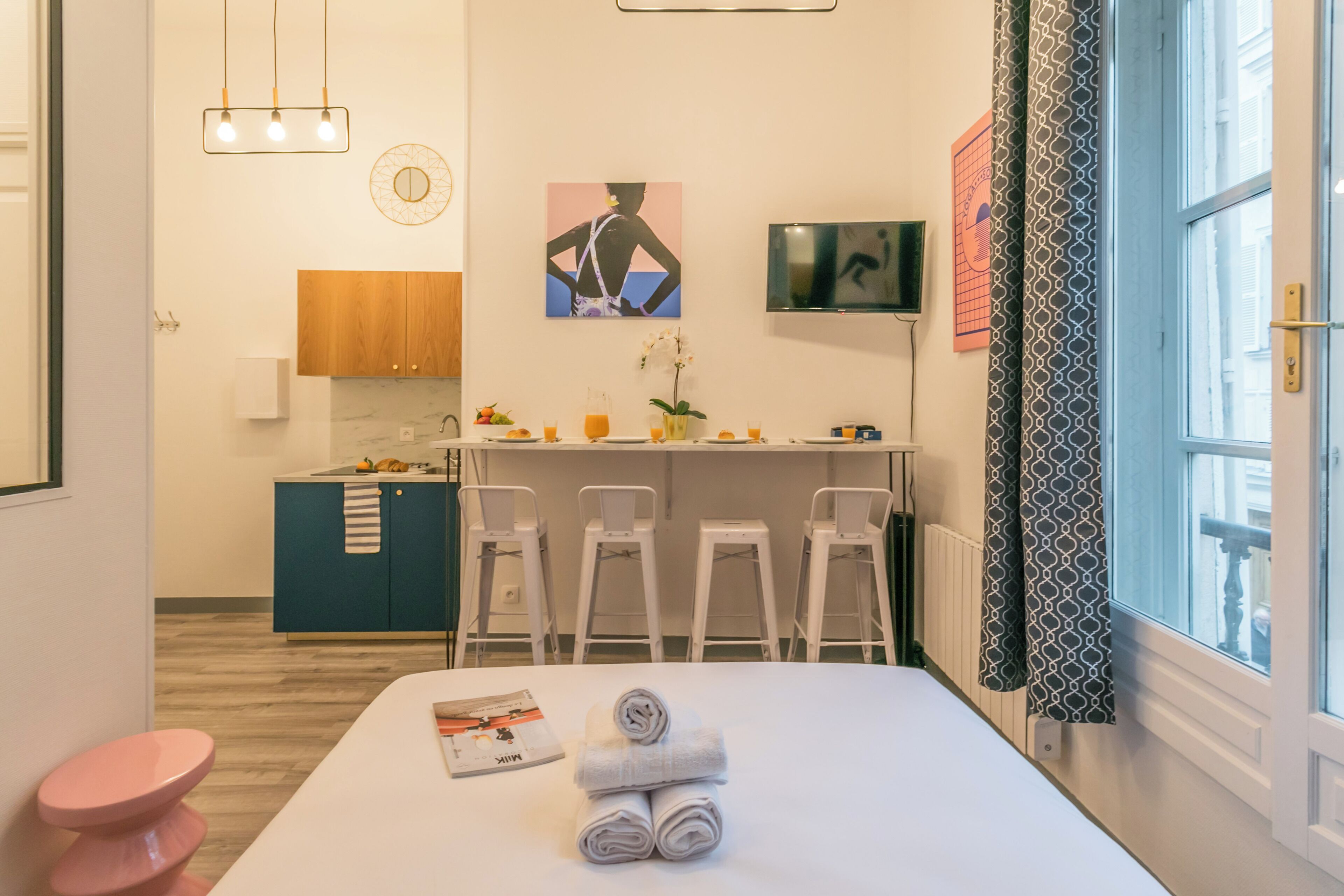 Une chambre d’hôtel comprenant un lit, un petit bureau, une kitchenette et une salle de bain.
