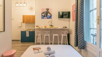 Une chambre d’hôtel comprenant un lit, un petit bureau, une kitchenette et une salle de bain.