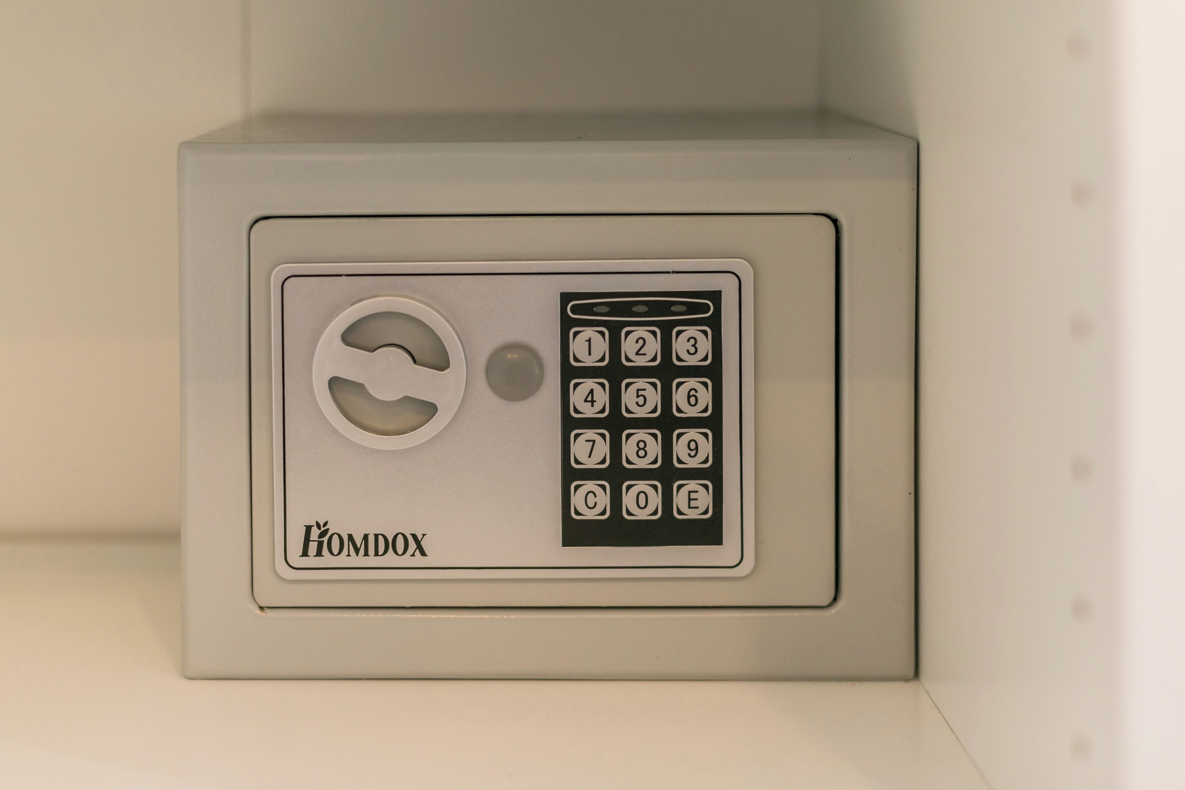 A secure, gray safe with a numeric keypad and a keyhole, labeled "HOMDOX."