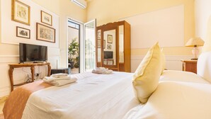 Une chambre d’hôtel avec un lit, une télévision, un bureau et un miroir.