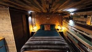 A narrow, wooden-paneled room with a bed centered, flanked by two nightstands with lamps. - Romantic Rural Retreat - Rustic Cabin in the Mournes with Private Hot Tub (Annalong)