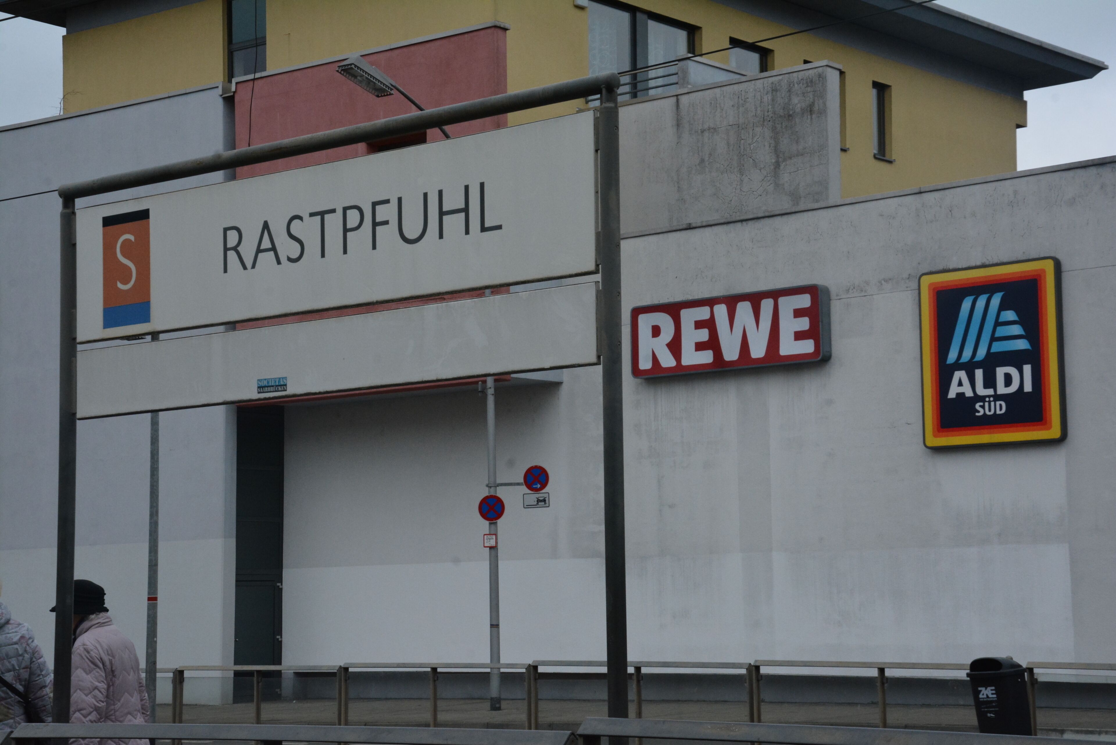 A building with signs for 'RASTPFUHL' and 'REWE ALDI Süd'.