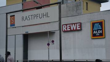 A building with signs for 'RASTPFUHL' and 'REWE ALDI Süd'.