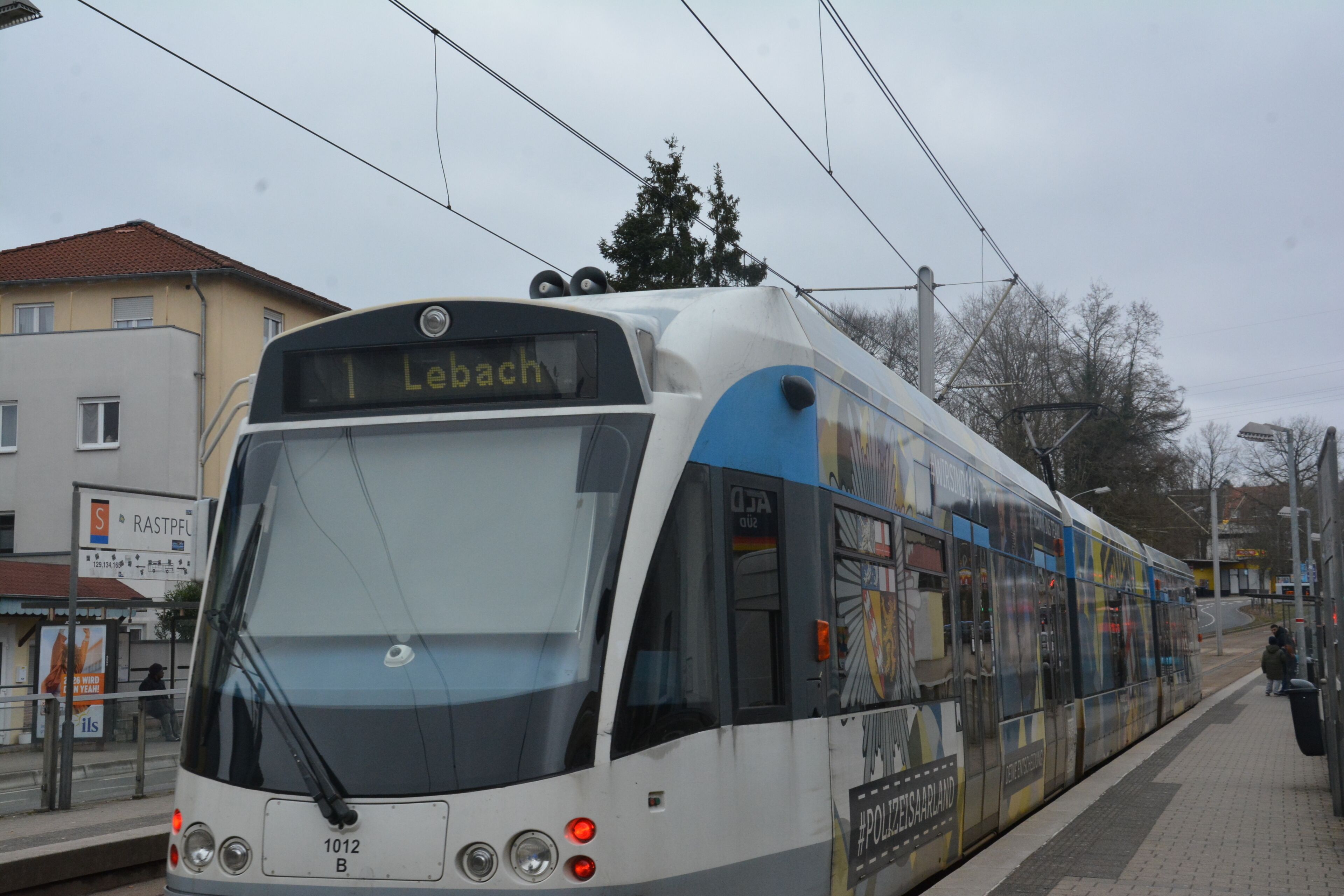 A modern tram with destination sign 'Lebenach' at a station platform.