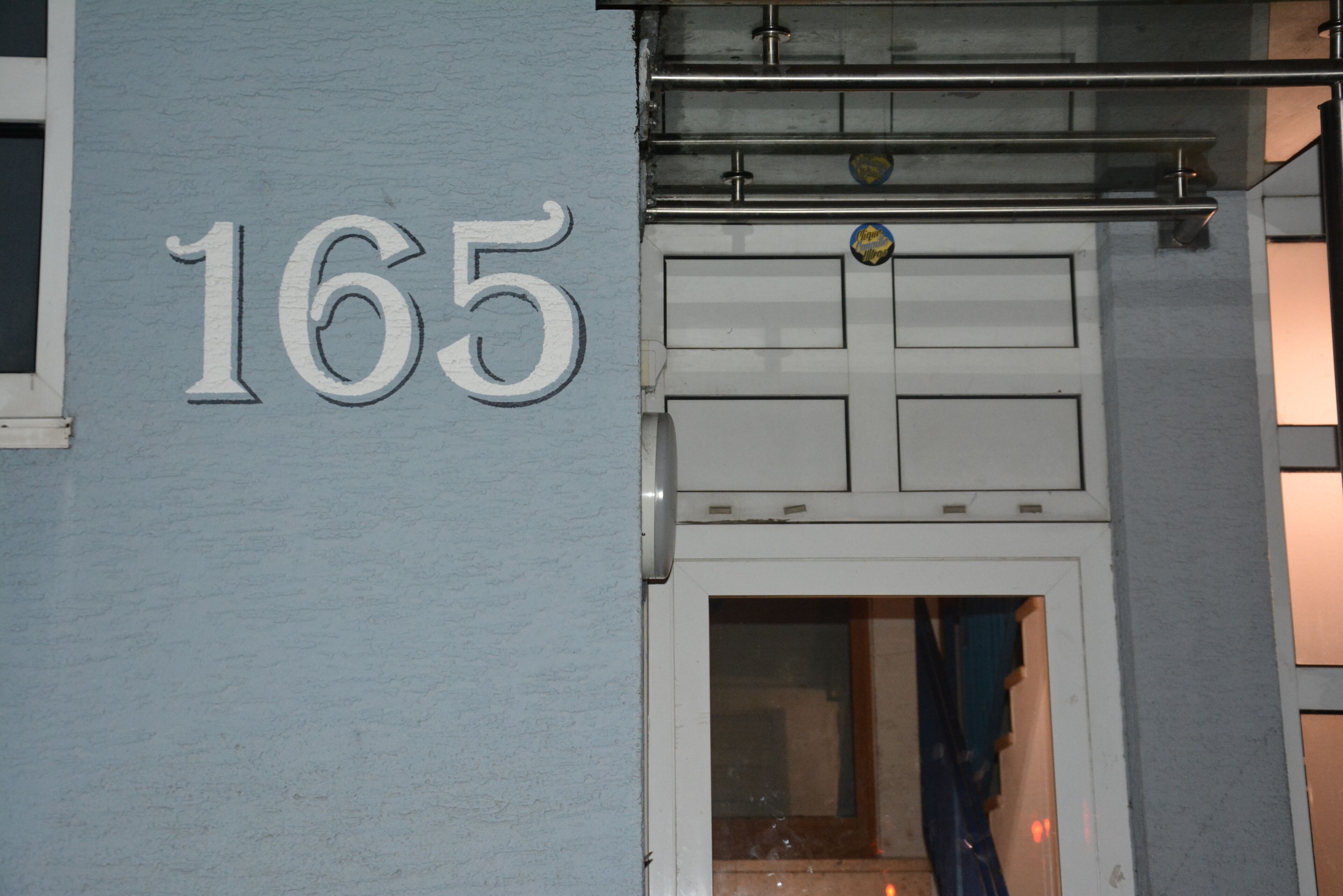 La façade d’un immeuble sur laquelle le numéro 165 est clairement visible.