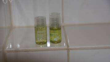 Two bottles of hair and body wash on a tiled shelf.