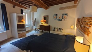 Un dormitorio con cama, cómoda, espejo y obras de arte.