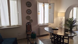 Un comedor con una mesa redonda, sillas y una planta en maceta.