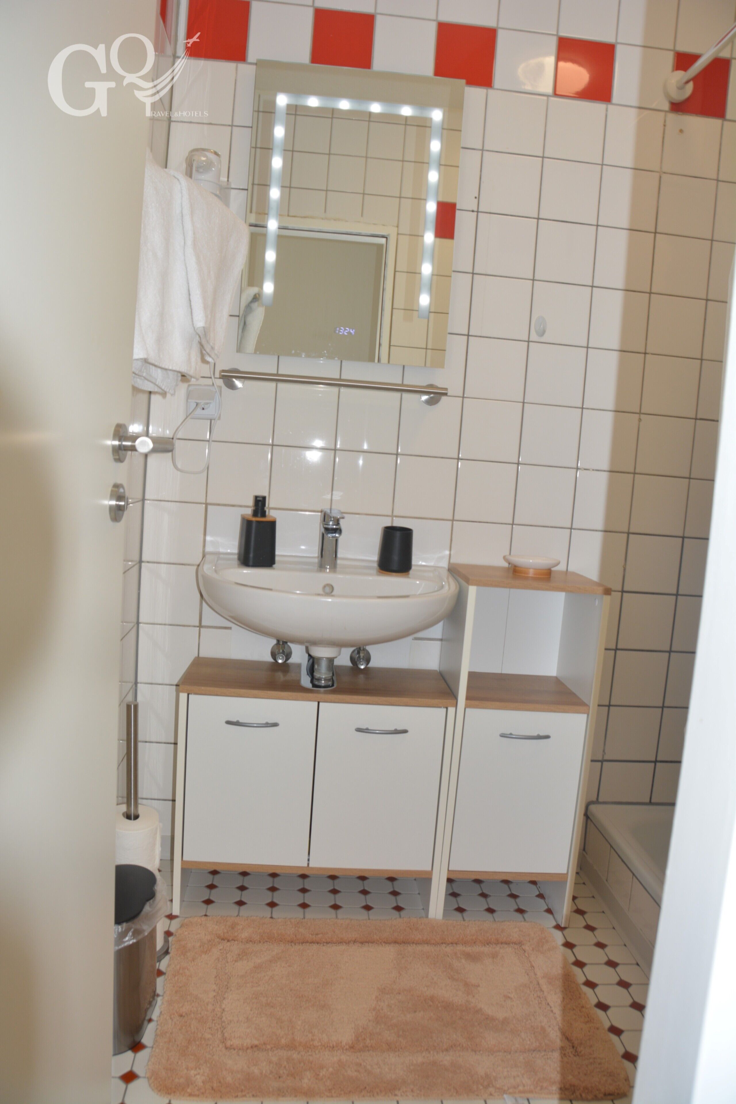 Ein Badezimmer mit Waschbecken, Spiegel und gefliesten Wänden.