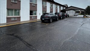 A multi-story motel with a parking lot. - Grand Inn (Moorhead)