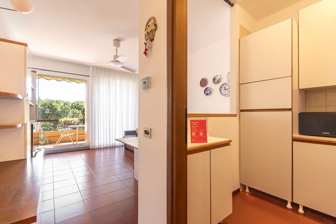 A modern kitchen with white cabinets, a Samsung refrigerator, and a dining area with a table and chairs.