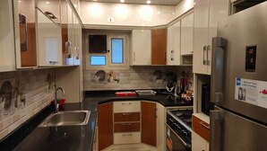 A modern kitchen with stainless steel appliances, a double sink, and a window above the countertop. - Sea View Chic Apartment in Sharm (Sharm El Sheikh)