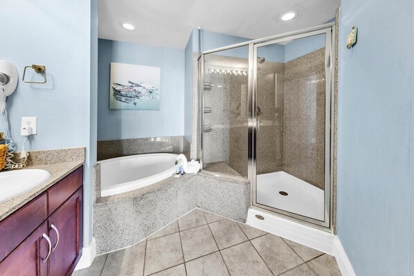 Une salle de bain moderne avec une baignoire sur pieds, une douche à parois de verre et un comptoir en granit.