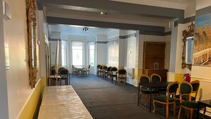 A hotel lobby with a long reception desk, multiple seating areas, and large windows allowing natural light. - The Ullswater House  (Bournemouth)