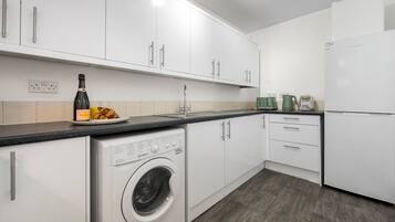 Een koffiezetapparaat/waterkoker, een koelkast, een magnetron, een oven