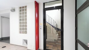 A modern interior with a glass door leading to a staircase. - WS Montorgueil-Louvre (Paris)
