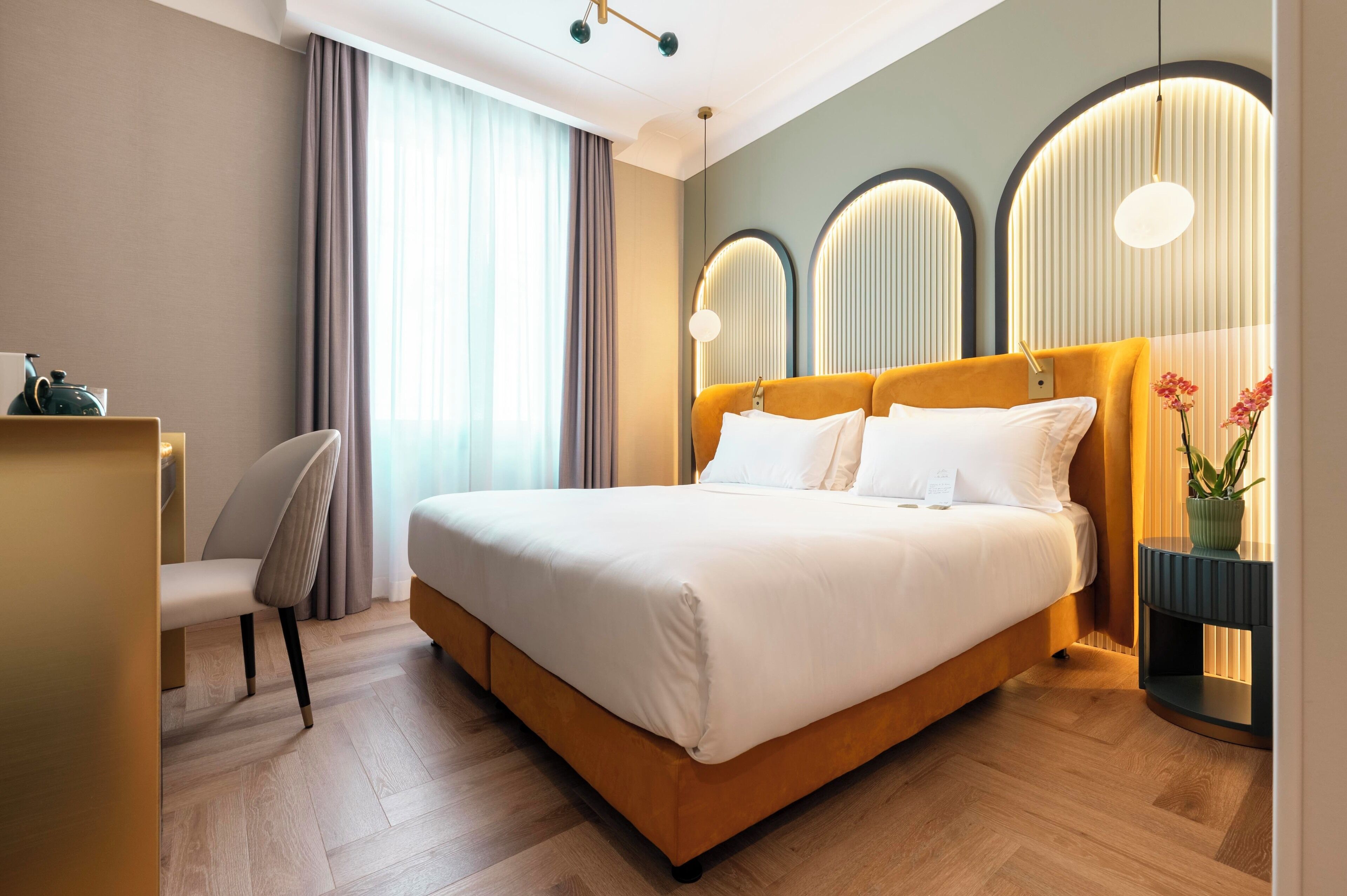 Een moderne hotelkamer met een groot bed, een bureau en een stoel.