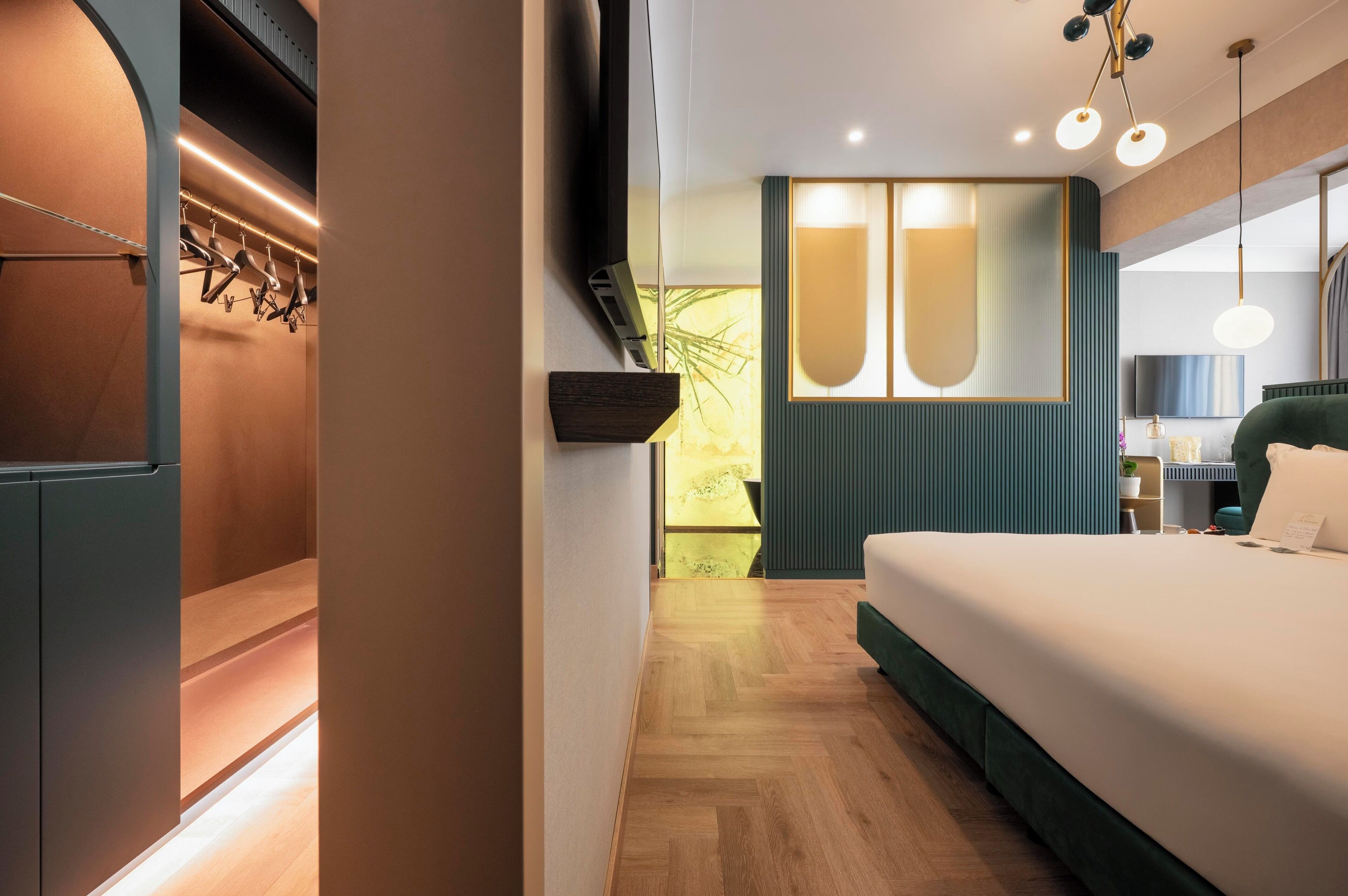 Ett modernt hotellrum med en säng, en TV och en sittgrupp med utsikt över omgivningarna.