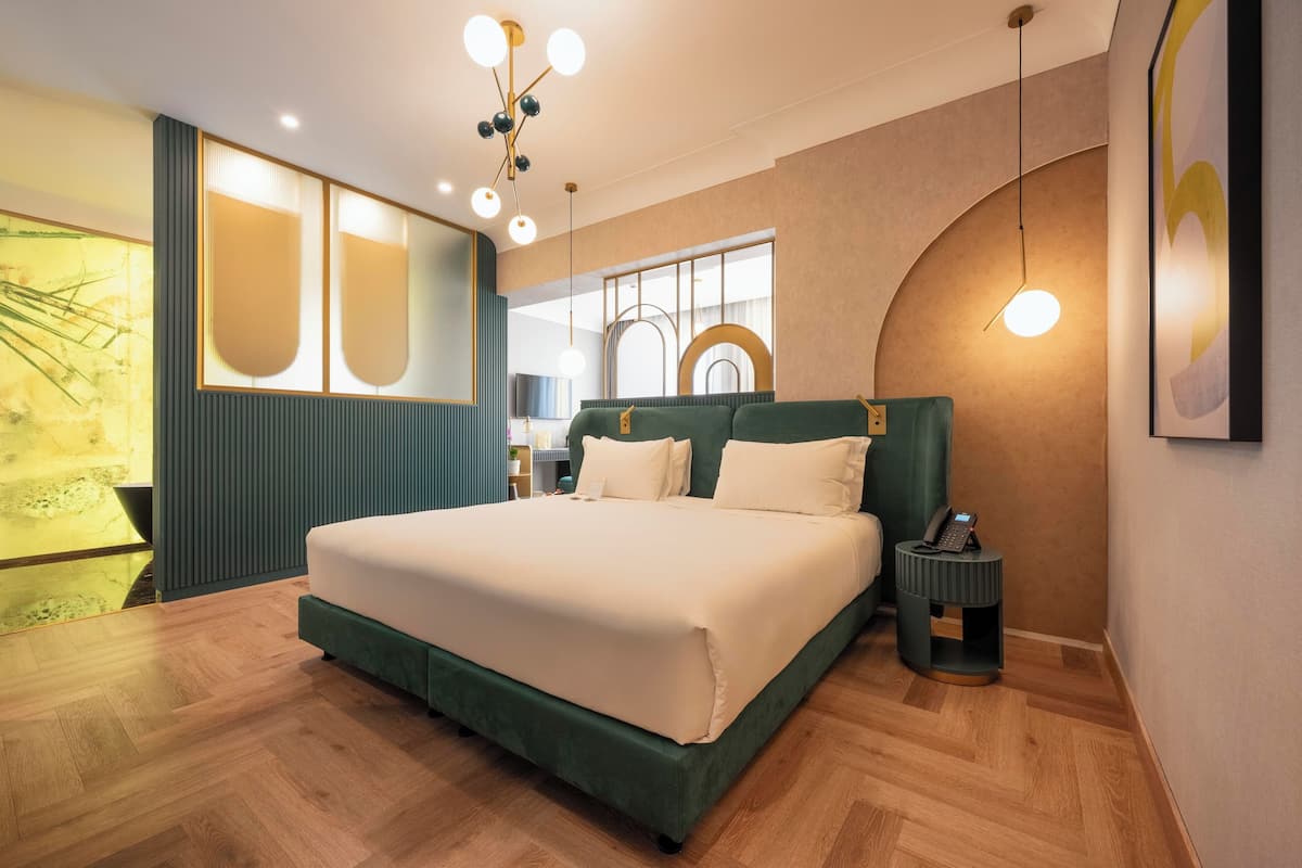 A modern bedroom with a large bed, a bedside table with a phone, and a unique wall design.