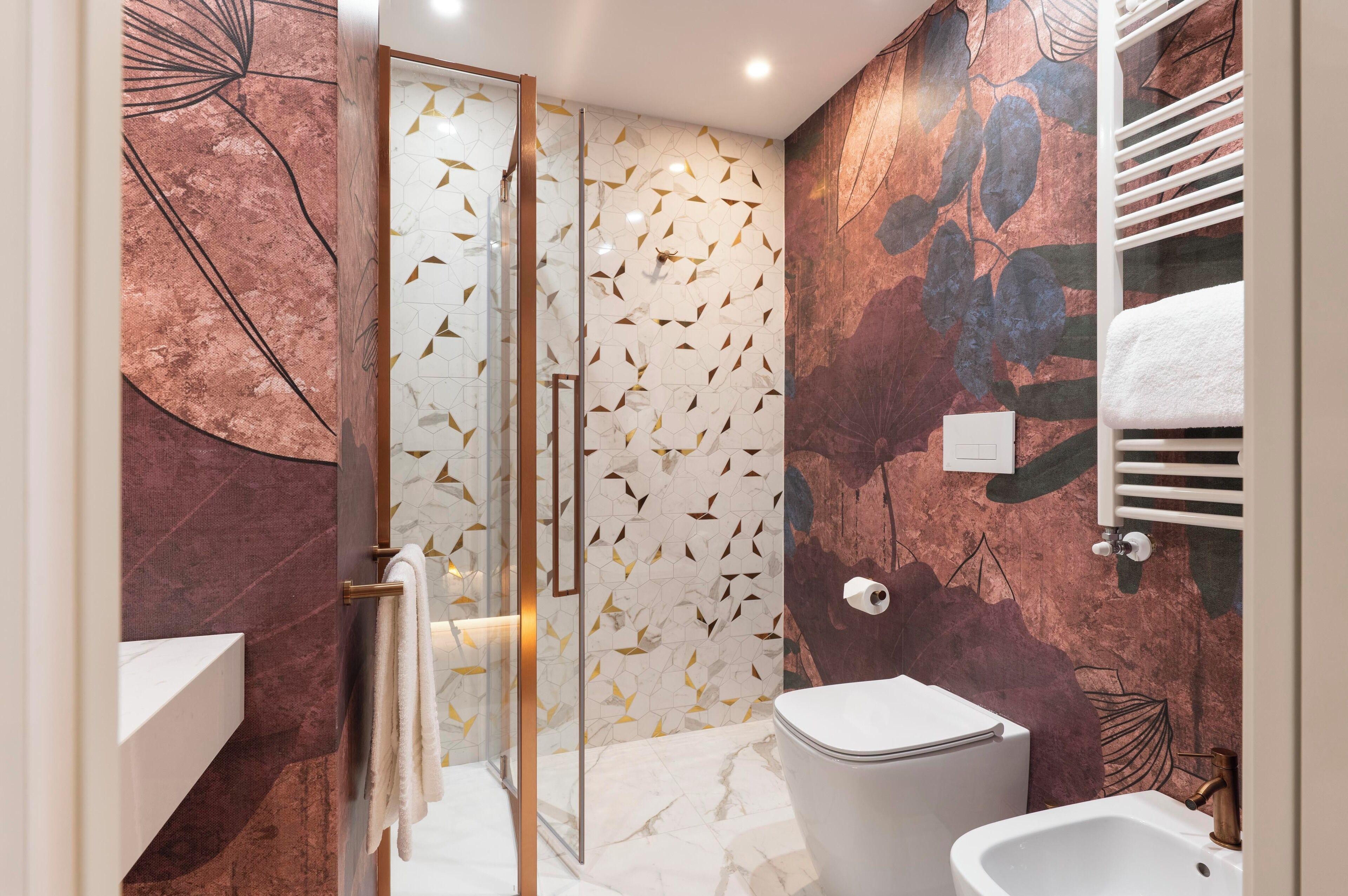 Un bagno moderno con box doccia in vetro, lavabo in marmo e WC.