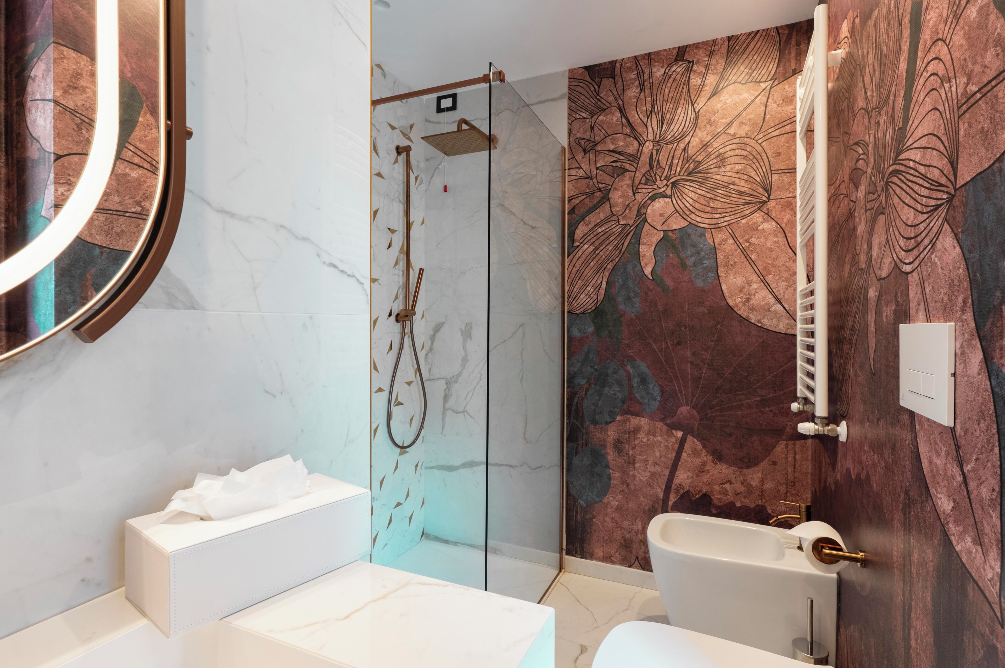 A modern bathroom with a marble vanity, a glass-enclosed shower, and a large mirror.
