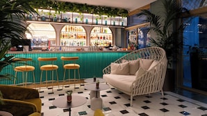 Un área de bar con suelo a cuadros, un sofá y taburetes.