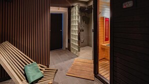 A modern bathroom with a shower, a bench with a towel, and a wooden wall design. - The Private Escape by Blue Medi Spa (Stockholm)