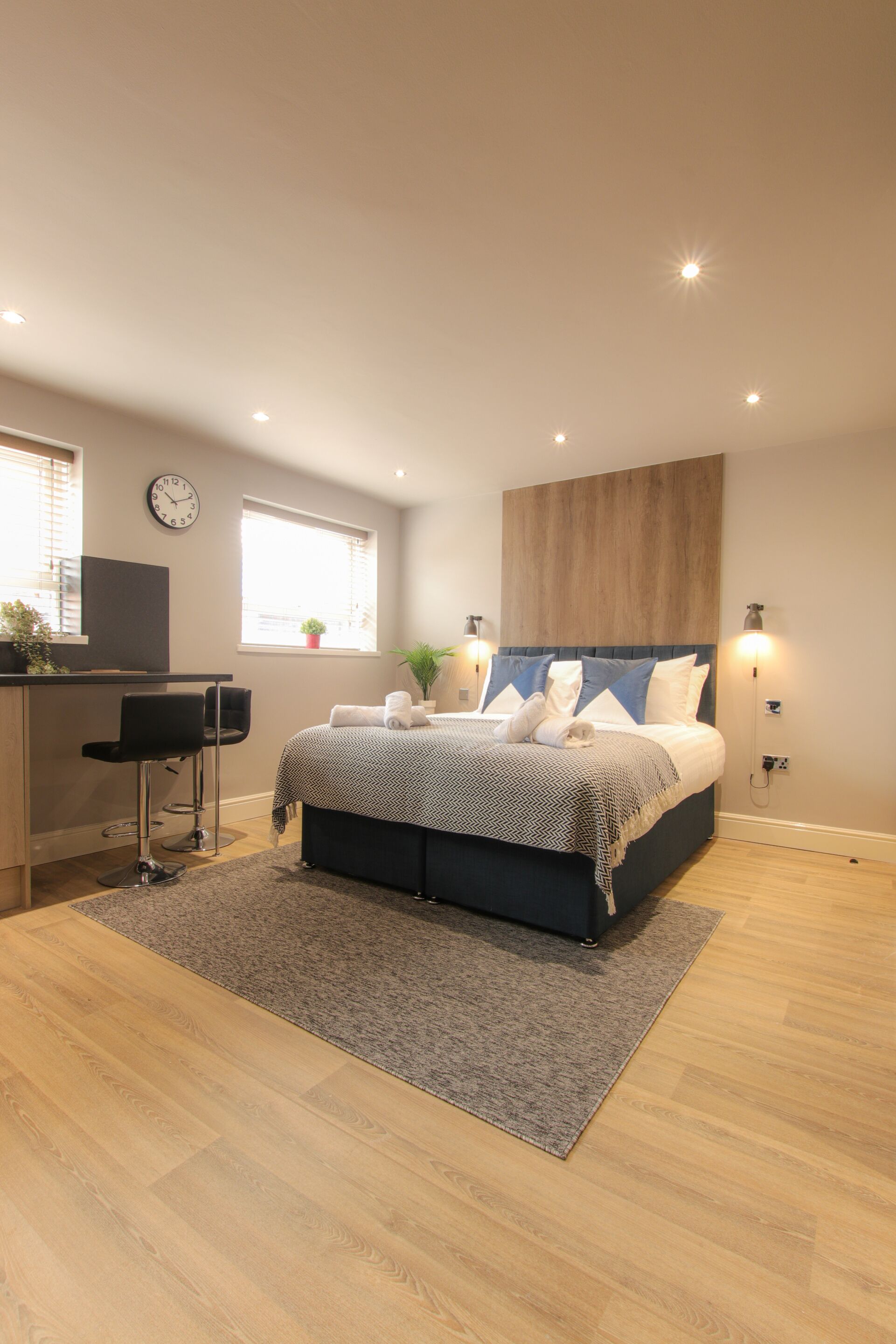 A bedroom with a bed, a desk, and a chair.