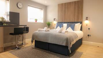 A bedroom with a bed, a desk, and a chair.