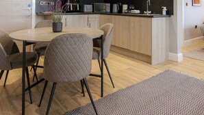 Une cuisine moderne avec des meubles en bois, un plan de travail noir et un îlot central doté de sièges.