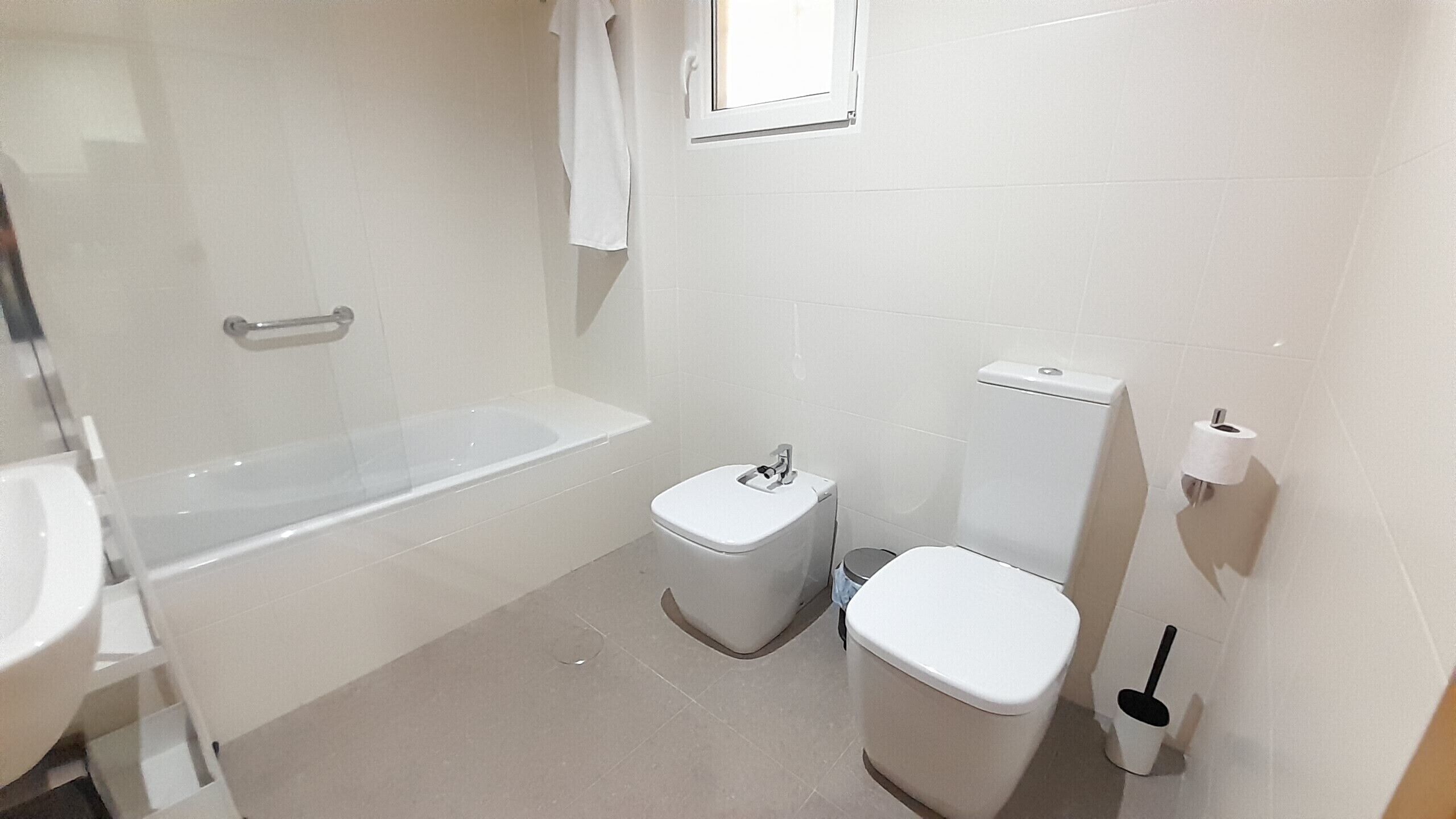 A bathroom with a bathtub, toilet, and sink.