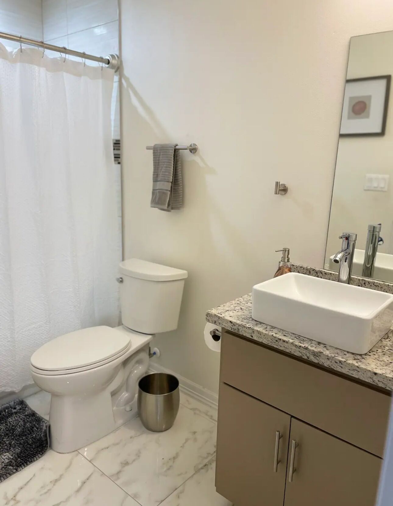 A bathroom with a toilet, sink, and shower curtain.