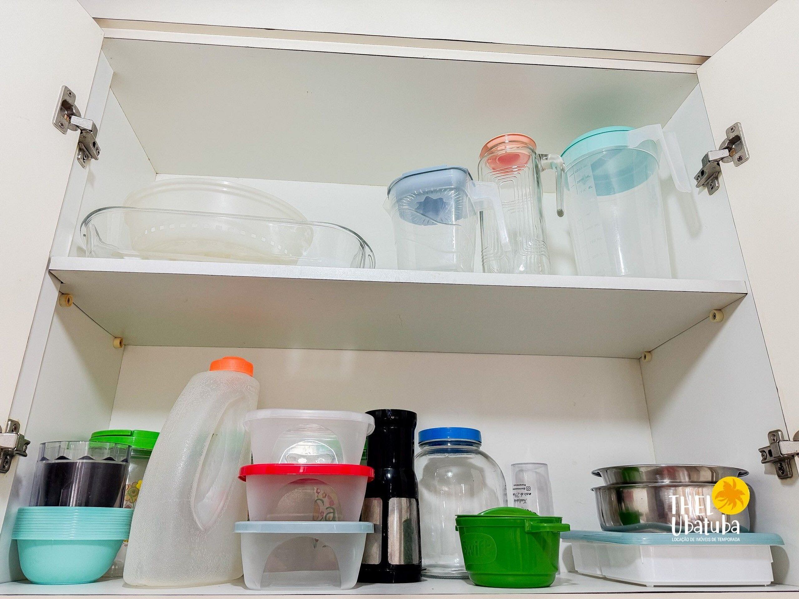 A kitchen cabinet with various storage containers and kitchenware.