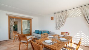 A dining area with a wooden table set for four, surrounded by wooden chairs. - Sweet Mavy Incantevole Dimora by Wonderful Italy (Olbia)