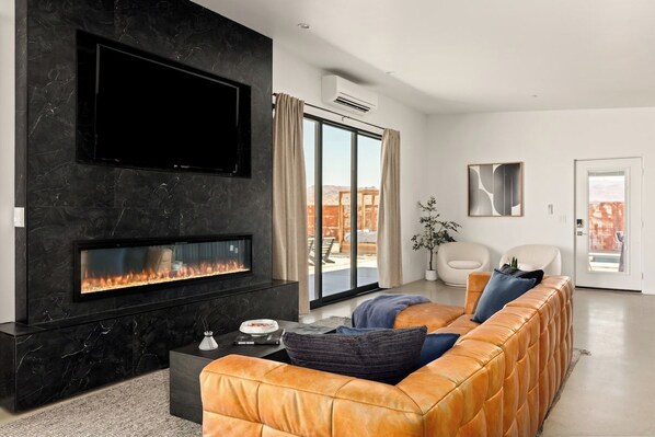 Cozy living room with a dramatic marble fireplace wall, 65-inch smart TV
