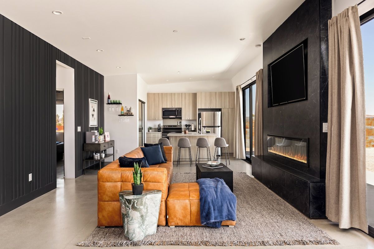 A modern living room with a sofa, a coffee table, and a fireplace.