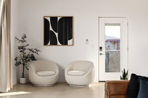 Cozy reading nook with sculptural boucle accent chairs, modern wall art