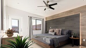 A modern bedroom with a wooden bed, a ceiling fan, a view of the outdoors, and a plant on the side table. - Joshua Tree Oasis • Pickleball • Pool • Jacuzzi (Joshua Tree)