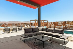 Shaded patio lounge with a large outdoor sectional overlooking the pool