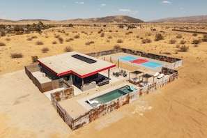 Un resort en el desierto con piscina, mobiliario exterior y vistas del paisaje circundante.