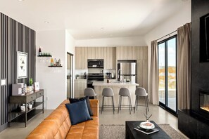 A modern living room with a sofa, a coffee table, and a fireplace.